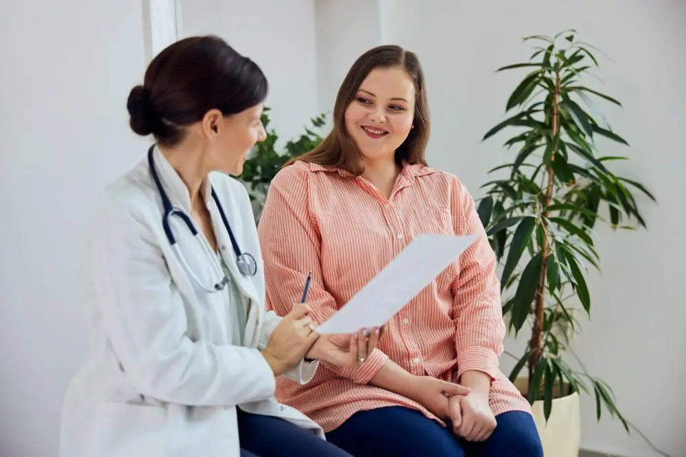 A woman sitting next to a doctor in front of a paper.