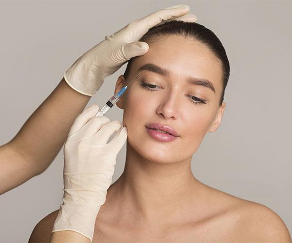 A woman getting her face waxed by an esthetician.