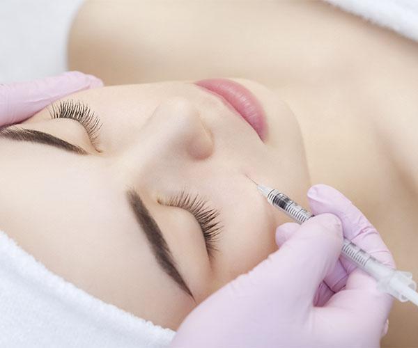 A woman getting her face waxed at the spa