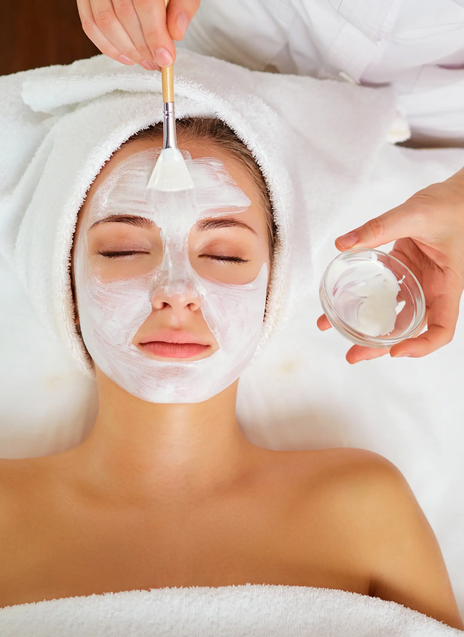 A woman getting her face washed with a glass of water.